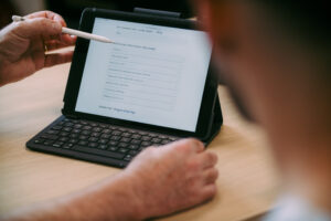 Vein,Specialist,Points,To,Question,On,Tablet,Discussing,Consent,Process,For,Varicose,Vein,Treatment.