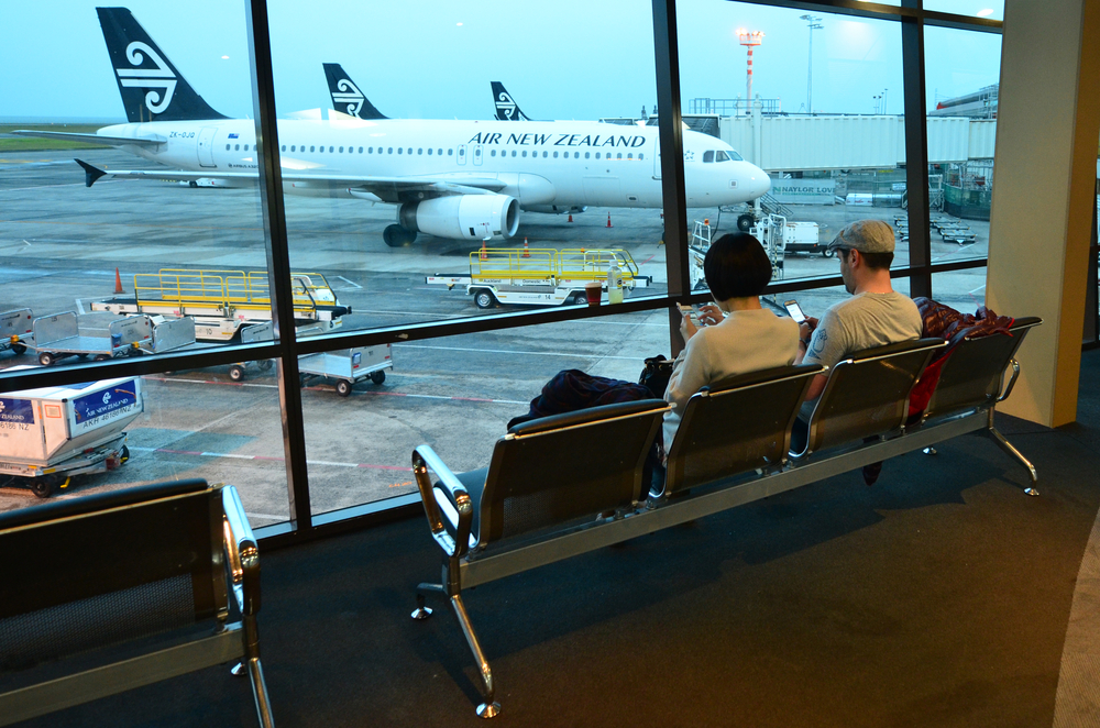 Fly,Long,Distance,People,On,Phones,Sitting,Looking,Out,At,Air,NewZealand,Plane.
